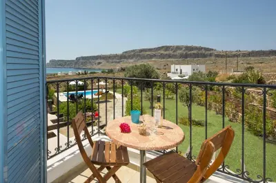 a table and chairs on a balcony with a view at Villa Aqua Blu by Villa Plus in Líndos