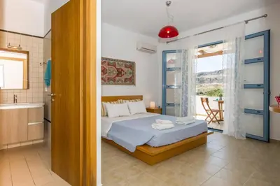 a bedroom with a bed and a bathroom at Villa Aqua Blu by Villa Plus in Líndos
