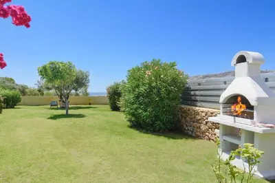 a fireplace in a yard with a stone wall at Villa Aqua Maris by Villa Plus in Líndos