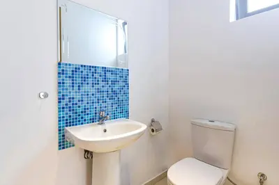 a bathroom with a white toilet and a sink at Villa Castello by Villa Plus in Líndos