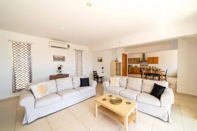 a living room with two white couches and a table at Villa Castello by Villa Plus in Líndos