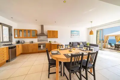 a kitchen and dining room with a table and chairs at Villa Castello by Villa Plus in Líndos