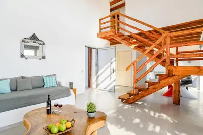 a living room with a staircase and a table at Villa Chloe Seastone by Villa Plus in Kiotari