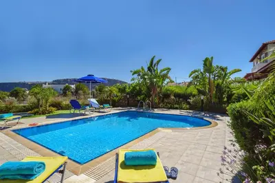 a swimming pool with two chairs and an umbrella at Villa Christina Rhodes by Villa Plus in Líndos