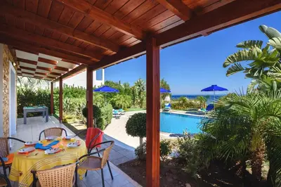 a patio with a table and chairs and a swimming pool at Villa Christina Rhodes by Villa Plus in Líndos