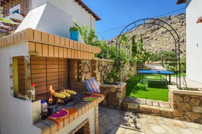 a backyard with an outdoor grill with a picnic table at Villa Christina Rhodes by Villa Plus in Líndos