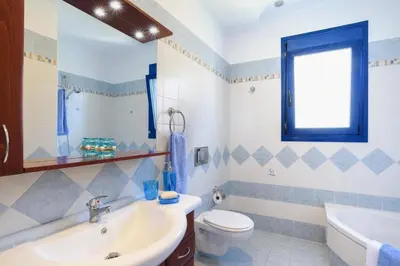 a bathroom with a sink toilet and a window at Villa Christina Rhodes by Villa Plus in Líndos