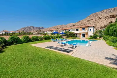 a large yard with a swimming pool and a house at Villa Clive by Villa Plus in Líndos