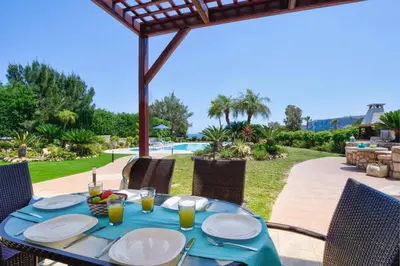 a table with plates of food on a patio at Villa Clive by Villa Plus in Líndos