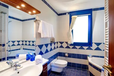 a blue and white bathroom with a toilet and a sink at Villa Clive by Villa Plus in Líndos