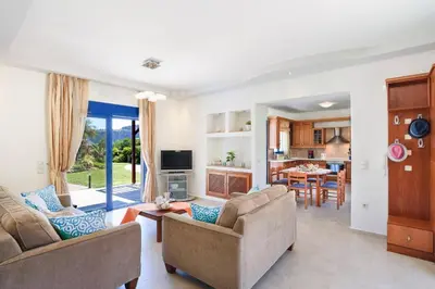a living room with two couches and a kitchen at Villa Clive by Villa Plus in Líndos
