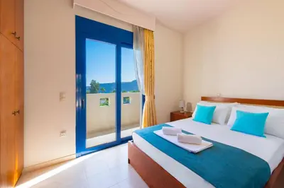 a bedroom with a large bed with a large window at Villa Clive by Villa Plus in Líndos