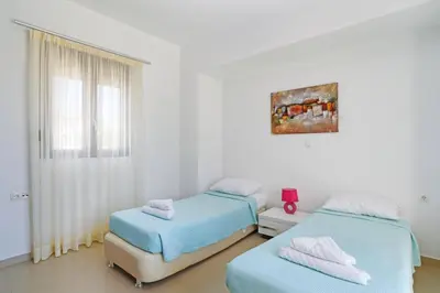 a room with two beds and a window in it at Villa Despina by Villa Plus in Pefki Rhodes