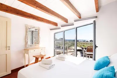 a bedroom with two beds and a balcony at Villa Dione Seastone by Villa Plus in Kiotari