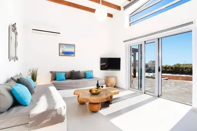 a living room with a couch and a table at Villa Dione Seastone by Villa Plus in Kiotari