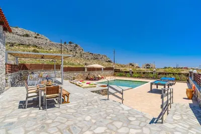 a villa with a swimming pool and a patio at Villa Dione Seastone by Villa Plus in Kiotari