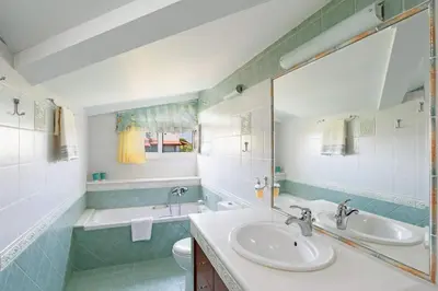 a bathroom with two sinks and a tub and a toilet at Villa Helios Rodos by Villa Plus in Asgourou
