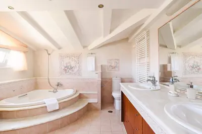 a bathroom with two sinks and a tub and a toilet at Villa Helios Rodos by Villa Plus in Asgourou