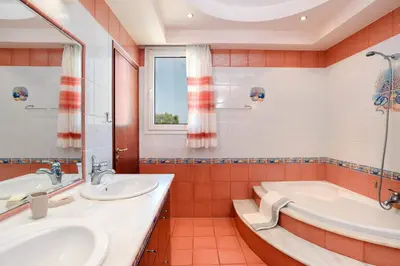 a bathroom with two sinks and a tub at Villa Helios Rodos by Villa Plus in Asgourou