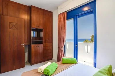 a bedroom with a bed and a large window at Villa Matina by Villa Plus in Líndos