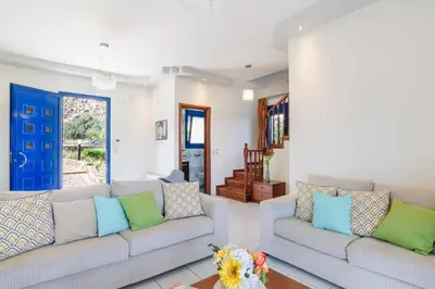 a living room with two couches and a blue door at Villa Matina by Villa Plus in Líndos
