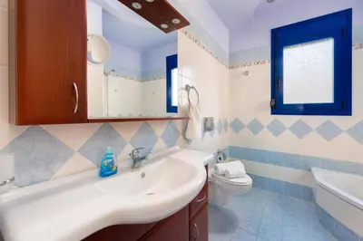 a bathroom with a sink and a toilet at Villa Matina by Villa Plus in Líndos