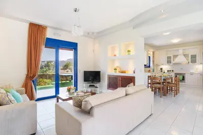 a living room with two couches and a kitchen at Villa Matina by Villa Plus in Líndos