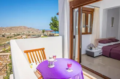 a room with a table with wine glasses on a balcony at Villa Maya by Villa Plus in Pefki Rhodes