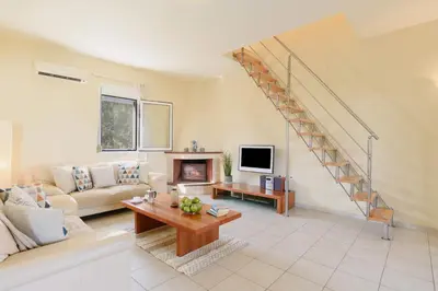 a living room with a couch and a staircase at Villa Selini by Villa Plus in Pefki Rhodes