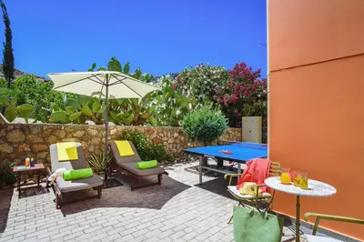 a patio with a table and chairs and an umbrella at Villa Selini by Villa Plus in Pefki Rhodes