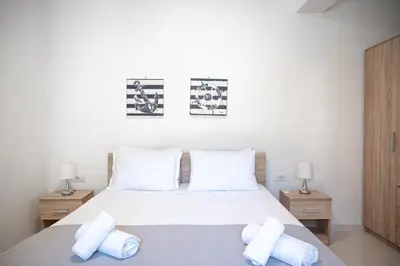 a bedroom with a bed with white sheets and pillows at Asterashouse in Rhodes Town