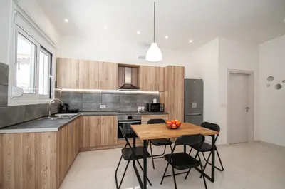 a kitchen with a wooden table with chairs and a counter at Asterashouse in Rhodes Town