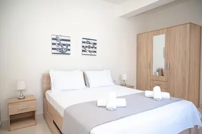a bedroom with a large white bed with two white towels at Asterashouse in Rhodes Town