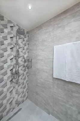a bathroom with a shower with gray tiles at Asterashouse in Rhodes Town