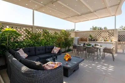 a patio with a couch and a table at Villa Gaia Green-Adults only in Kolimbia