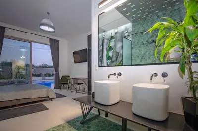 two sinks in a room with a bedroom at Villa Gaia Green-Adults only in Kolimbia