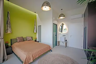 a bedroom with a bed and a green wall at Villa Gaia Green-Adults only in Kolimbia