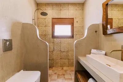 a bathroom with a toilet and a sink and a mirror at Stavlos Luxury Stone House in Ialyssos