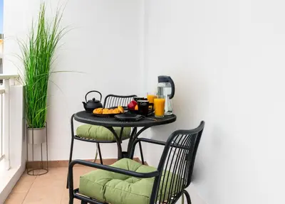 a table with two chairs and a table with food on it at Port Living Apartments in Rhodes Town