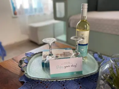 a plate with a bottle of wine and two glasses at Kleopatra Sweet Home in Symi