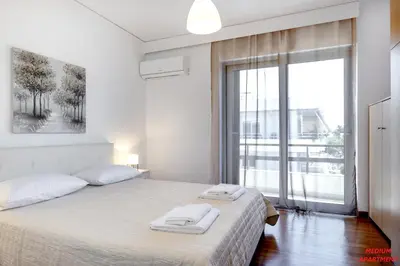 a bedroom with a bed and a large window at Rhodes Heart Apartments close to the old town in Rhodes Town