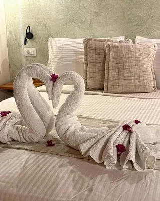 two swans towels are sitting on a bed at Midgard Suites (Medieval Town) in Rhodes Town