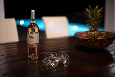 a bottle of wine sitting on a table with a bowl of fruit at Villa Maribia with Private pool in Gennadi