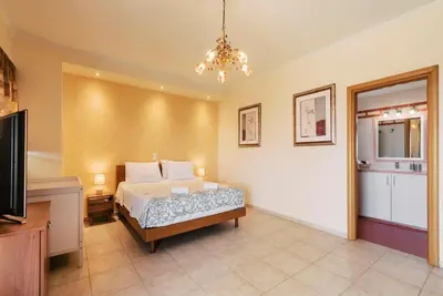 a bedroom with a bed and a chandelier at Villa Maribia with Private pool in Gennadi