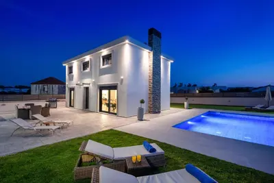 a villa with a swimming pool at night at Rhodes Villa Billys in Asgourou