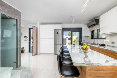 a kitchen with a long table with black chairs at Rhodes Villa Billys in Asgourou