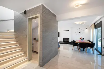a staircase in a living room with a table and chairs at Rhodes Villa Billys in Asgourou