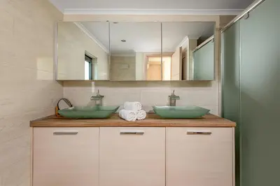 a bathroom with two green sinks and a mirror at Rhodes Villa Billys in Asgourou