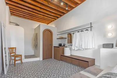 a bedroom with a bed and a desk and a chair at Peni sol Superior Studios Lindos in Líndos