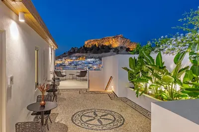 a balcony with a table and chairs and a view at Peni sol Superior Studios Lindos in Líndos